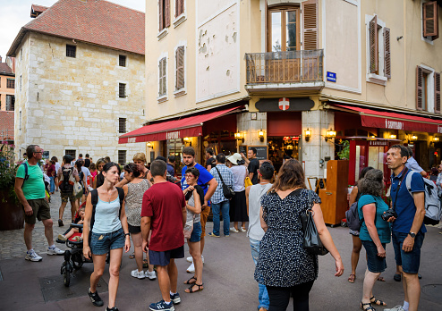 Annecy, France - Aug 15, 2017: Large crowd of people at in front of O Savoyard restaurant in central part of the city walking discovering the old city of Annecy on rue Pont Morens