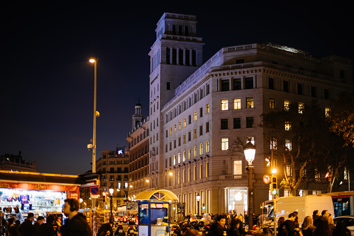 Barcelona, Spain - Nov 17, 2017: Iconic Placa de Catalunya with hundreds of people at dusk and iconinc Apple Store Passeig de Gracia
