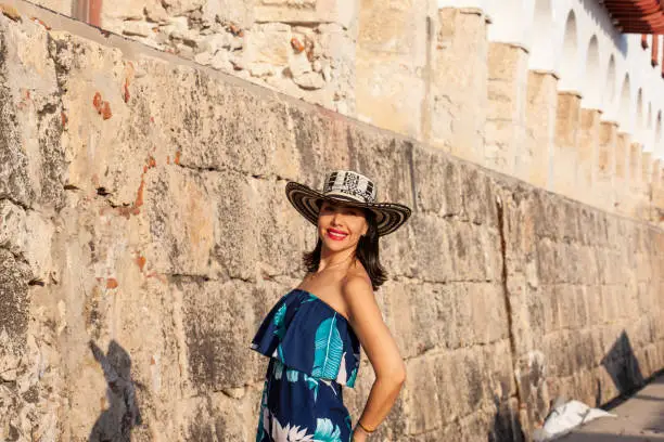 Beautiful woman wearing the traditional Colombian hat called Sombrero Vueltiao at the historical Calle de la Ronda of the Cartagena de Indias walled city