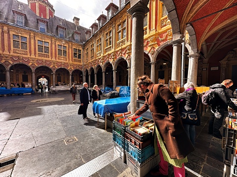 Lille, France - April 12 2023: people on the courtyard with book stalls in the old stock exchange in the historic old town