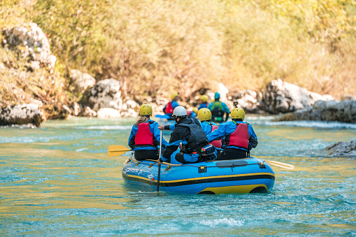 Diverse mid adults engaging with nature, expertly led by their guide on a thrilling mountain river rafting journey.