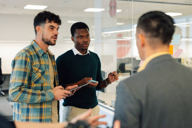 istock Group of male multiracial business team using sticky notes on the glass wall 2021360998