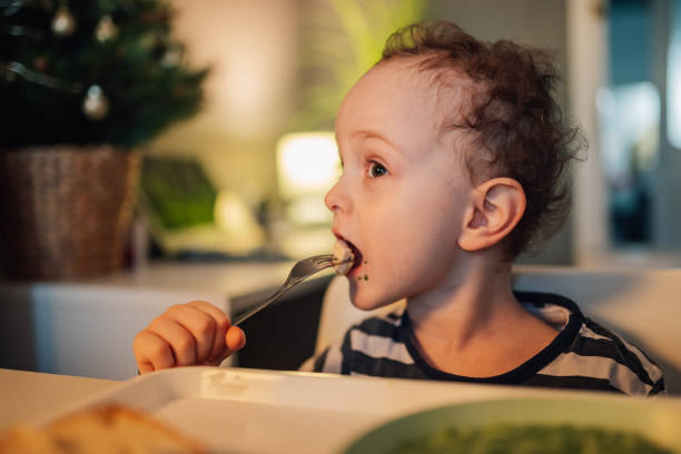 istock A hungry child is biting his lunch while sitting at dining table at home. 2021361546