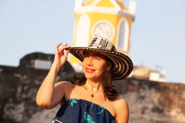Beautiful woman wearing the traditional Colombian hat called Sombrero Vueltiao at the Clock Tower on the historical streets of the Cartagena de Indias walled city