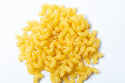 Heap of raw elbow macaroni (Pasta Gomiti) Isolated on white background, Cut with clipping path, Top view