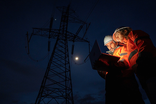 Innovative Electrical Utility services. Team solving issues at night.