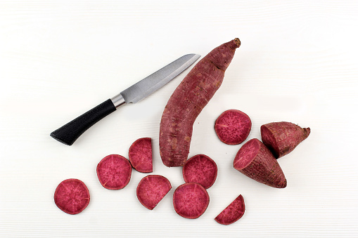 Slicing Purple Red Japanese Sweet Potato in Various Slice, over White Background