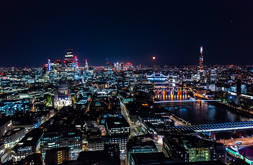 Beautiful night view of London city with illuminated lights from building and streets under black sky.