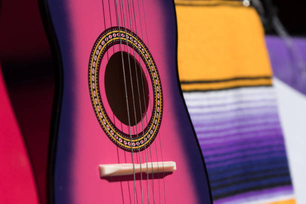 Hands of a guitarist playing an acoustic guitar during an outdoor concert.
