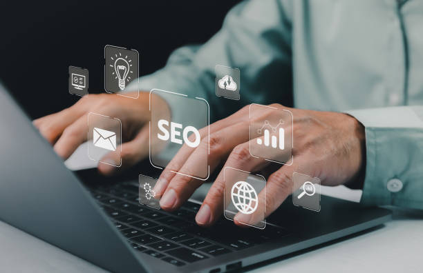 istock Hands typing on a laptop, with translucent SEO and digital marketing icons floating above, symbolizing online strategy planning. Search Engine Optimization Marketing Website Internet Technology. 2021574431