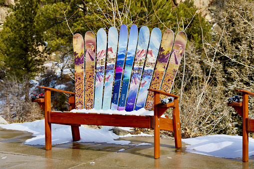 Buena Vista, Colorado, USA - February 10, 2024: A unique two-person bench made in part from skis that have been painted await users on the Arkansas River Trail on a winter afternoon.
