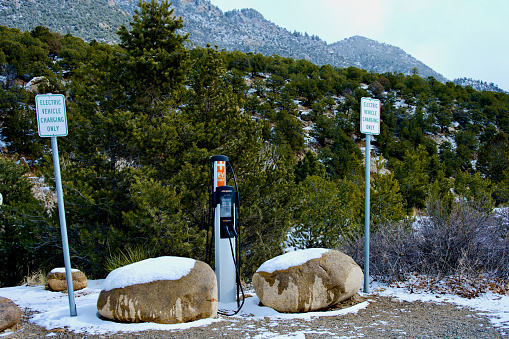 Buena Vista, Colorado, USA - February 10, 2024: An electric vehicle (EV) charging station stands out in contrast to the surrounding natural environment at a public park along the Arkansas River.
