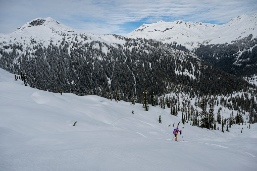 Aerial view of backcountry skier climbing snow covered mountain