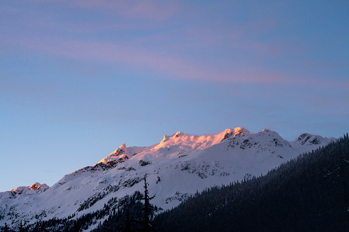 Sunrise light on snowcapped mountains and fresh snow coverage