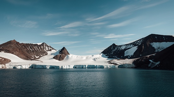 Antarctica Glacier Tongue Panorama on a sunny day. Coastal Seascape with view over into Antarctic Glacier Lagoon - Glacier Bay. Glacier Tongue and Coastal Mountains under sunny blue skyscape. Toned Image. Panorama Shot. Antarctica Peninsula, Antarctica