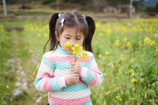 little girl smelling flowers