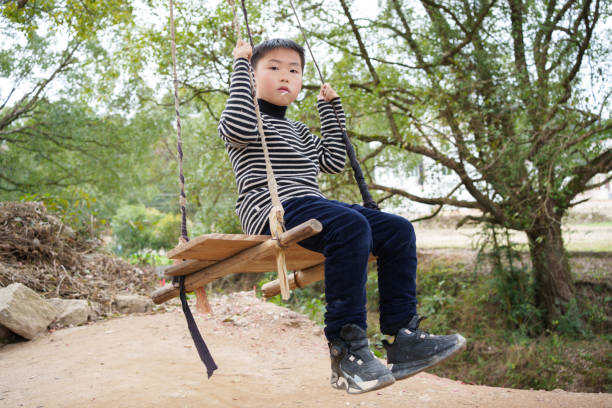 swing with wooden seat and handle made of nylon rope in the garden.