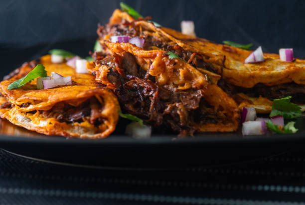 istock 3 Beef Birria Tacos Stacked on Black Plate 2021972015