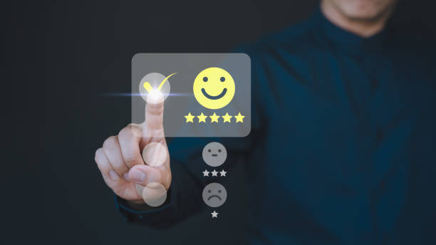istock Customer hand touching the virtual screen on happy smile face icon to give satisfaction in service. Concept of assessment testimonial customer service and feedback, Opinion rating very impressed. 2021984979