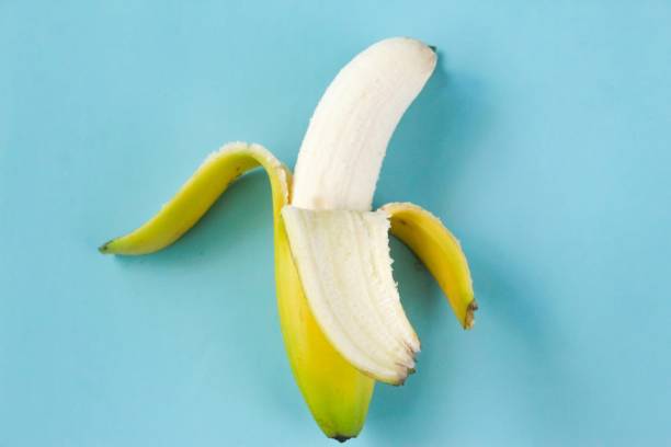 istock a peeled banana, on a blue background 2021990071