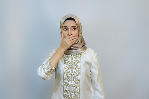 Woman covering ears, eyes, and mouth to shield from negativity, on white background
