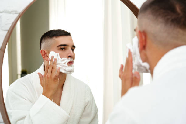 istock Reflection of a young man shaving in bathroom mirror close up 2021998041