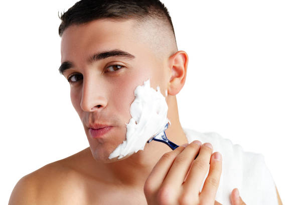 istock Young handsome man applying shaving foam against white background 2022011504