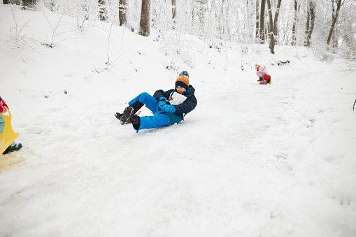 Photo of a beautiful children on a winter day sliding.
