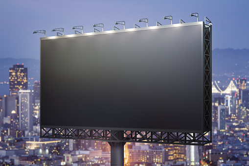 Blank black horizontal billboard on skyline background at evening, perspective view. Mock up, advertising concept