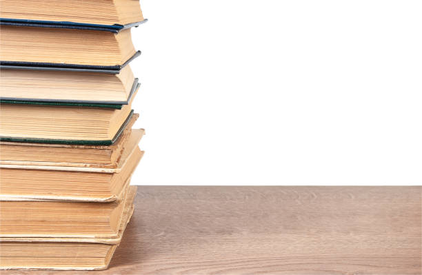 istock Stack of old books on wooden surface isolated on white background 2022081334