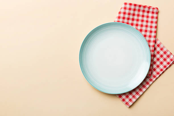 istock Top view on colored background empty round blue plate on tablecloth for food. Empty dish on napkin with space for your design 2022086109