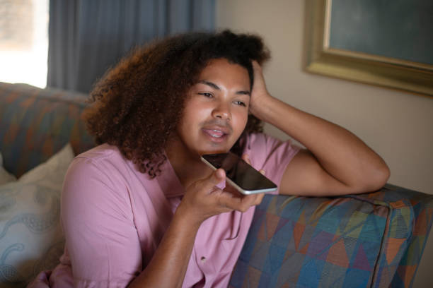 istock Home, phone call and speaker with man, connection and relax with digital app and network. Apartment, person and guy on a sofa and cellphone with contact and talking with conversation and mobile user 2022091915