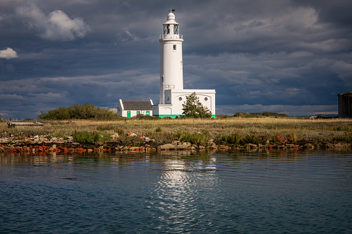 Near Milford on Sea,, Hampshire, England, UK - September 29, 2022: The Hurst Point Lighthouse and Keyhaven Lake
