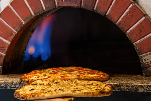 istock Mixed pizza fresh from the pizza oven with flames visible in the background 2022098847