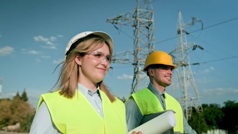 Project team of energy auditors performing inspection of electricity pylons