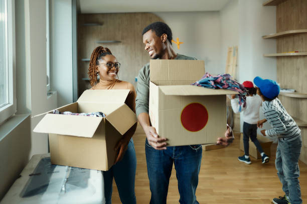 istock Happy black parents talking while carrying boxes in a new apartment. 2022103677