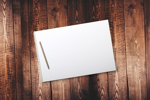 Pen on top of notepad on wooden background