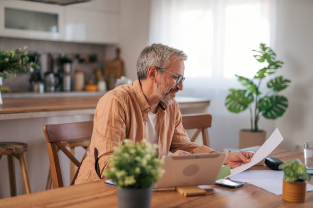 istock A man at his cozy home looking at the laptop, working on paperwork and solves home finances. 2022106367