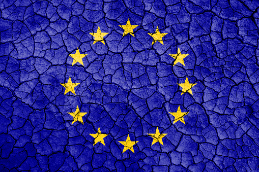 Cracked earth with word Europe Union flag. Global warming, climate change concept. Carbon dioxide emission concept in EU