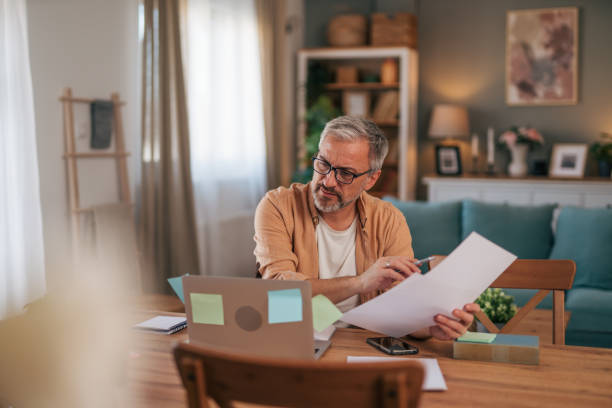 istock A mature man is holding a piece of paper with a pensive expression. 2022109217