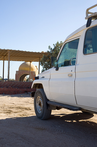 Hurghada, Egypt, January 20, 2024: White Land Cruiser for safari stands on sandy parking lot in the desert of Egypt
