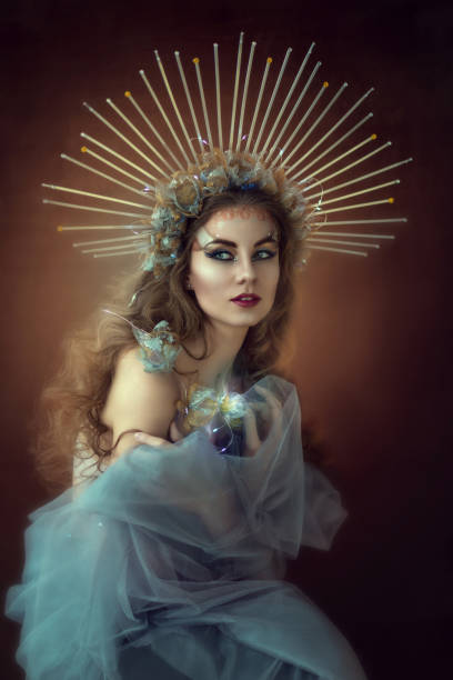 прекрасная принцесса с длинными вьющимися волосами в золотой короне. голубое прозрачное платье. историческая женщина, леди, королева гламу - women crown princess 20s стоковые фото и изображения