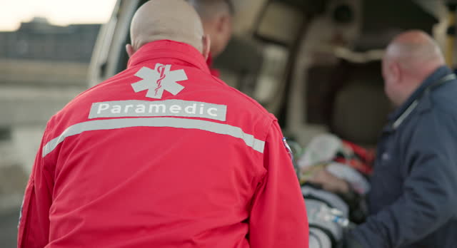 Paramedic, ambulance and man with first aid in emergency, care or transport to hospital for injury or accident. EMT, service and people in healthcare, save a life or rescue person from car crash