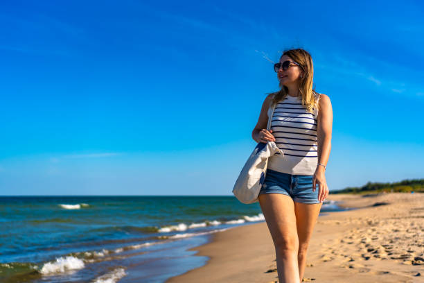 istock Beautiful woman walking on beach 2022159288