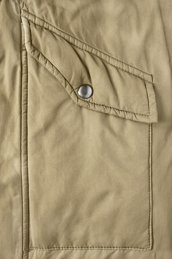 Khaki jacket flap patch pocket closeup as a background