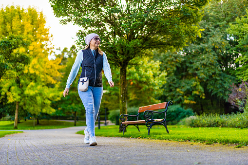 Beautiful mid-adult woman walking in city park