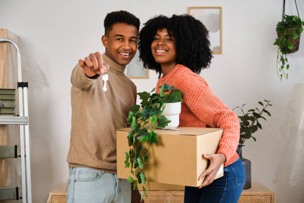 Portrait of happy young black moving in a new home. Portrait of happy young black moving in a new home. New residence relocation. key package stock pictures, royalty-free photos & images