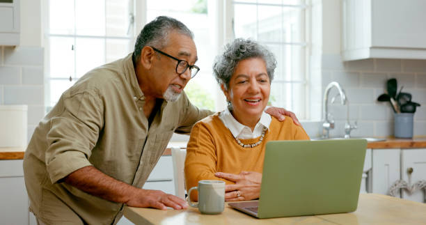 Senior couple, kitchen and laptop for healthcare information at home, smile and learning for wellness. Internet, online programs and diet with nutrition, exercise tips and routine for retirement. pareja de personas mayores, cocina y computadora portátil con conexión en línea para transmisión, internet y navegación por el sitio web en casa. ideas, pasatiempos y suscríbete para ver entretenimiento con memes, videos divertidos para divertirte y