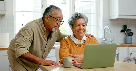 Senior couple, kitchen and laptop for healthcare information at home, smile and learning for wellness. Internet, online programs and diet with nutrition, exercise tips and routine for retirement.
