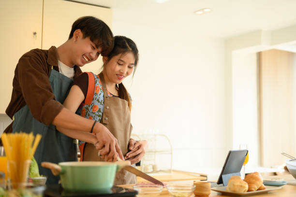 istock Romantic young couple preparing spaghetti while spending free time together at home 2022203708